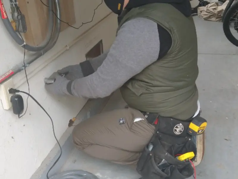 Electrician performing outlet wiring in a Cape Coral garage